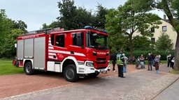 Ein Feuerwehrwagen und mehrere Menschen stehen vor der Heinrich-Böll-Gesamtschule in Bochum