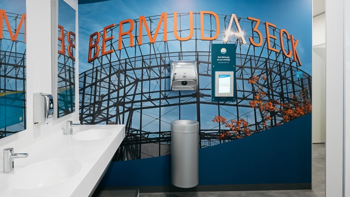 Die Sanifair WC-Anlage von innen mit großflächiger Wandgestaltung des "Bermuda3ecks"