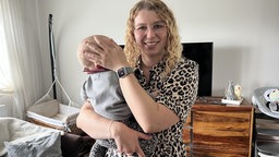 Kim Kloth hält ihr Baby im Arm.