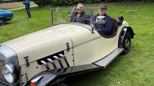 Zwei Männer sitzen in ihrem Borgwart Roadstar von 1951. 