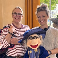 Jessica Helmke und Claudia Belinski mit dem Wunschzauberer-Maskottchen und einem Tornister