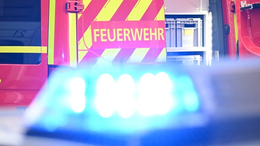 Blaulicht. Im Hintergrund ist der Schriftzug "Feuerwehr" zu sehen. 