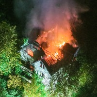 Helle Flammen auf dem Dach eines großen Gebäudes von oben