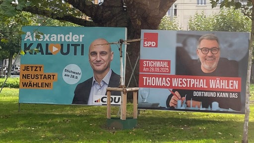 Auf dem Bild sind zwei Wahlplakate zu sehen