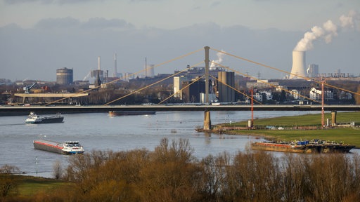 Ein Teil von Duisburg in einer Panoramaansicht. Links sind Frachter auf dem Rhein, darüber die Autobahn A40 Rheinbrücke Neuenkamp. Im Hintergrund das Thyssenkrupp Steel Stahlwerk in Bruckhausen und hinten rechts das Steag Steinkohlekraftwerk Walsum.