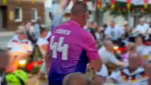 Ein Mann trägt ein pinkes Trikot. Auf dem Rücken ist die Nummer 44 zu sehen sowie der Schriftzug "Führer".