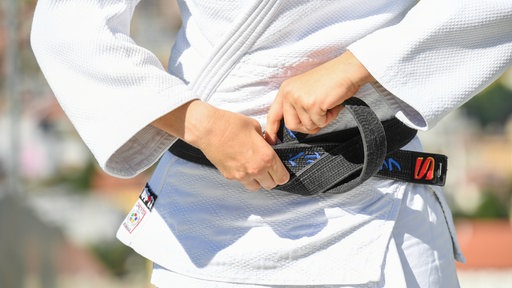 Judo-Kämpfer zieht Gürtel zurecht