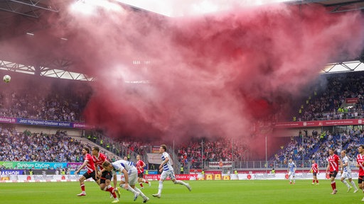 MSV Duisburg spielt gegen Energie Cottbus unter rotem Pyro-Rauch