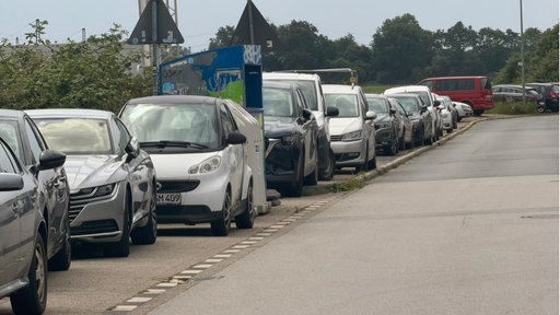 Viele Autos stehen am Straßenrand.
