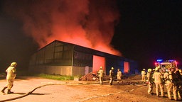 Feuerwehrmänner löschen Feuer in Scheune