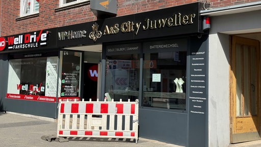 Vor dem Juwelier-Geschäft in Moers steht eine Absperrung.