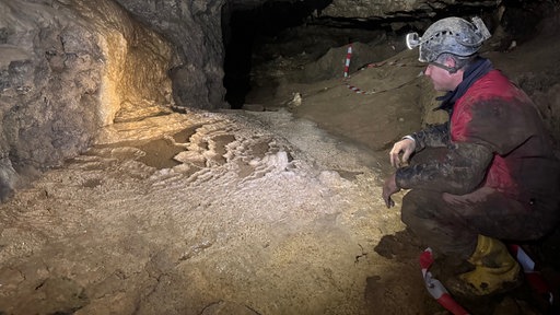 Ein Forscher blickt auf das entdeckte Sinterbecken in der Paradieshöhle Ennepetal 