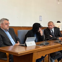 Angeklagter sitzt neben Verteidiger und Dolmetscher im Gerichtssaal