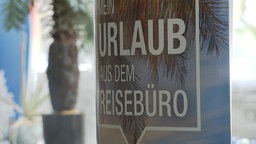 In einem Reisebüro in Gelsenkirchen, das Kunden betrogen haben soll, steht ein Schild mit der Aufschrift "Mein Urlaub aus dem Reisebüro"
