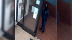 Ein dunkel gekleideter Mann mit Sturmhaube steht neben dem Kassenautomat eines Parkhauses