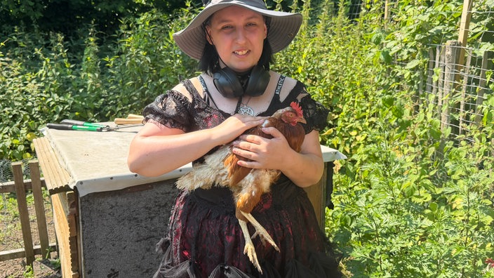 Frau hält Huhn im Arm