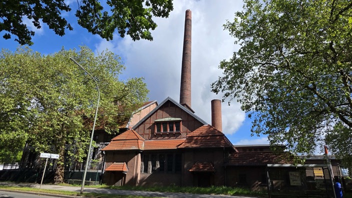 Ein Gebäude des alten Schlachthofs in Gelsenkirchen mit dem hohen Ziegel-Schornstein