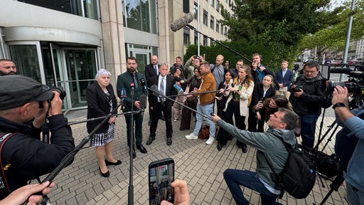 Kamerateams und Fotografen um Sparkassen-Opfer
