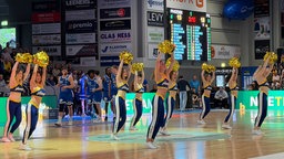 Cherleaderinnen von Phoenix Hagen feuern mit goldenen Puscheln während einer Spielunterbrechung an