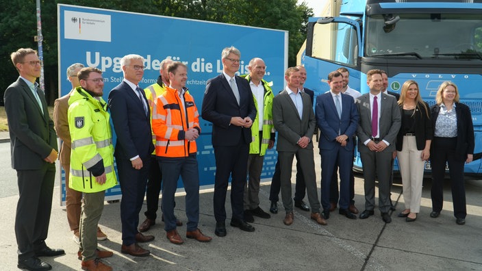 Mehrere Menschen vor einem Banner