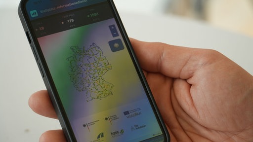 Eine Han, die ein Smartphone in der Hand hält, auf dem eine Karte zu sehen ist
