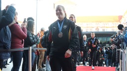 Spielerin Lisa Antl läuft mit ihrer WM-Silber-Medaille über einen Roten Teppich der Stadt Dortmund