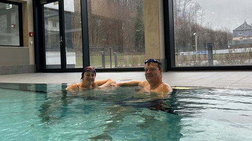 Zwei Personen in Badekleidung in einem Schwimmbecken