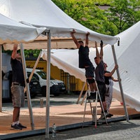 Vier Männer bauen ein Gastro-Zelt auf dem Altstadtmarkt auf.
