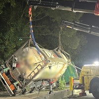 Zwei Kräne, die an einem verunfallten Lkw befestigt sind, richten das umgekippte Fahrzeug wieder auf. 