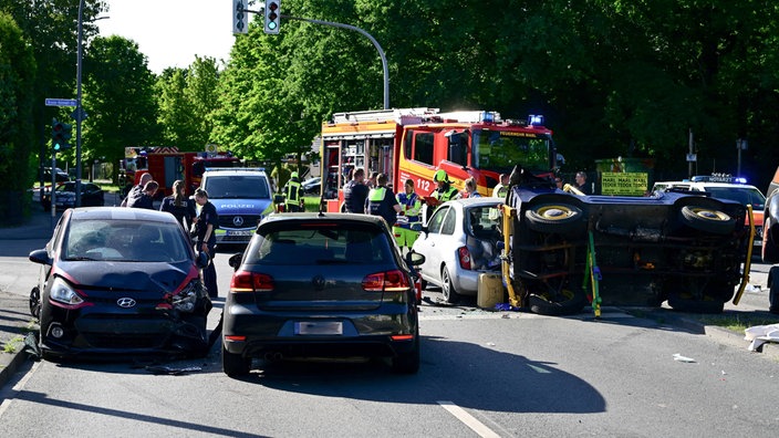 Vier Unfall-Fahrzeuge auf einer Straße in Marl. Im Hintergrund sind Feuerwehr und Polizei zu sehen.