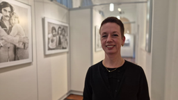 Isolde Parussel, die Leiterin des Hoesch-Museums steht neben zwei Ausstellungsstücken die an der Wand hängen.