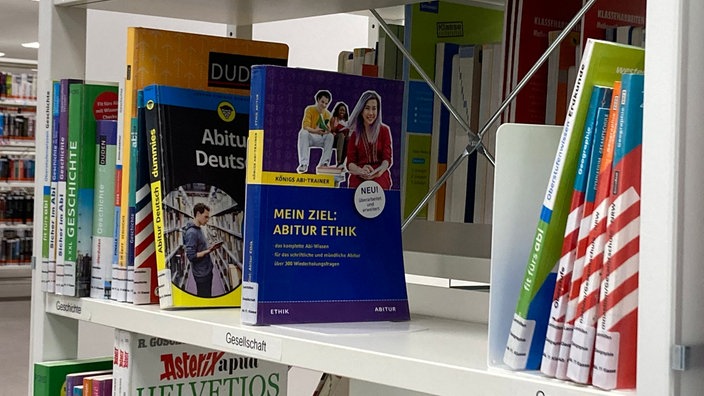 Bücher mit der Aufschrift "Mein Ziel: Abitur Ethik" und "Abitur Deutsch" stehen mit anderen Büchern in einem Regal