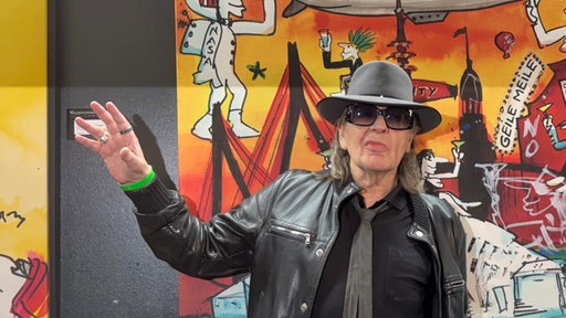 Udo Lindenberg vor einem Ausstellungsbild. 