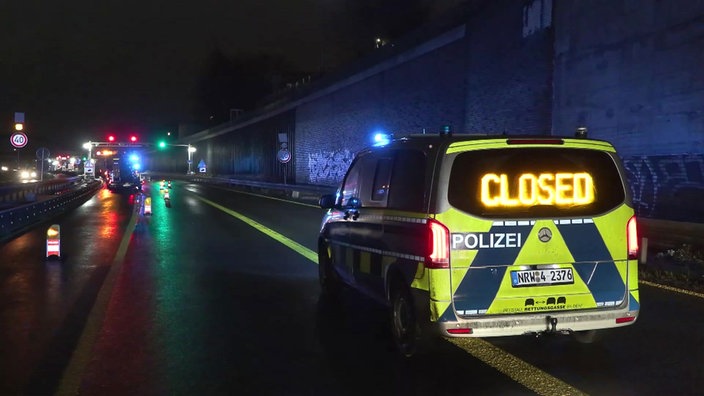 Ein Polizeibulli ist auf der A43 zu sehen, auf der Rückscheibe ist das Wort Closed eingeblendet, weil die Autobahn gesperrt ist