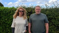 Frau und Mann mittleren Alters schauen in die Kamera