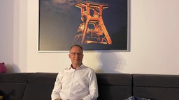 Ein Mann sitzt auf einem Sofa