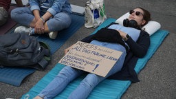 Eine Demonstrantin liegt auf dem Boden