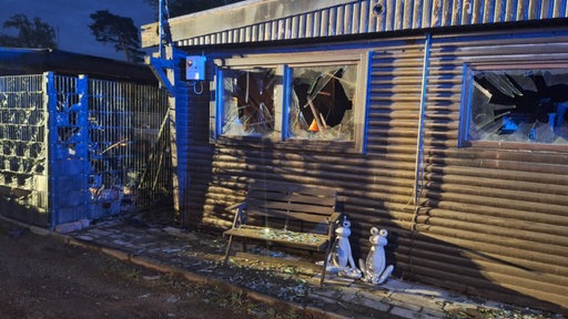 Die Fensterscheiben an einem kleinen Ferienhaus sind nach dem Brand auf dem Campingplatz zerborsten