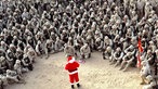 Eine Gruppe uniformierter US-Marines sitzen im Halbkreis um einen Mann, der sich als Weihnachtsmann verkleidet hat