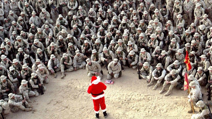 Eine Gruppe uniformierter US-Marines sitzen im Halbkreis um einen Mann, der sich als Weihnachtsmann verkleidet hat