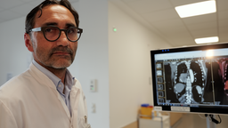 Arzt im Hintergrund ein Monitor der Bilder der Krebsbehaldnung zeigt