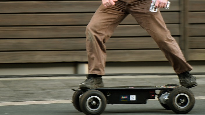Ein Mann fährt auf einem Elektro-Skateboard