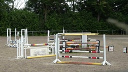 Mehrere Hürden die auf einem Reitplatz stehen