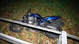 Das Unfall-Motorrad liegt hinter der Leitplanke im Gras. 