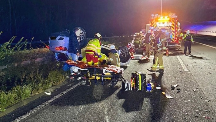 Einsatzkräfte der Feuerwehr bei der Rettung eines verunfallten Wagens. 