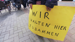 Gelbes Plakat mit dem Schriftzug "Wir halten zusammen"