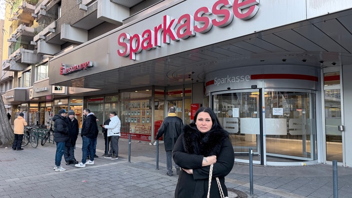Kundin steht vor der Sparkassenfiliale in Gelsenkirchen