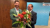 Thomas Kufen bekommt einen Blumenstrauß überreicht