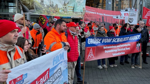 Vor dem Ruhrkongress in Bochum stehen protestierende Stahlarbeiter