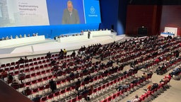 Bei der Hauptversammlung von Thyssenkrupp im Ruhrkongress in Bochum sitzt die Chefetage auf einer großen Bühne mit Leinwand, die Aktionäre sitzen auf Stühlen, einige sind leer